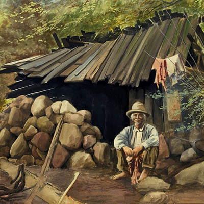 Man Seated in Front of Wooden Shack